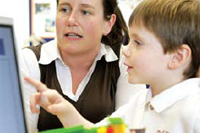 Teacher showing a child how to use a computer